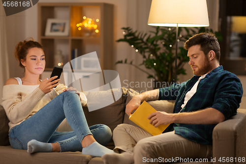 Image of couple with smartphone and book at home