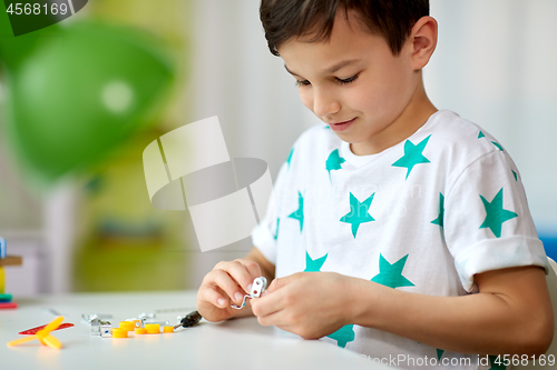 Image of little boy playing with building kit at home