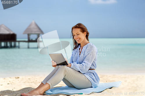 Image of happy smiling woman with tablet pc on summer beach