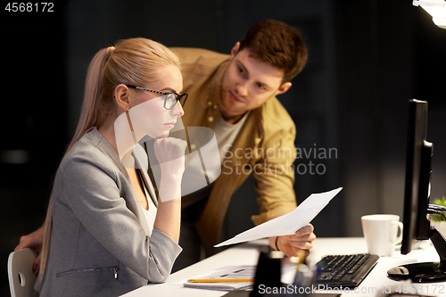 Image of business team with papers working at night office