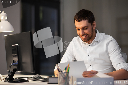 Image of businessman with computer working at night office