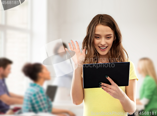 Image of student girl having video call on tablet at school