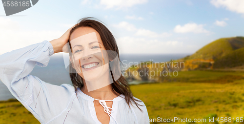 Image of smiling woman over big sur coast of california