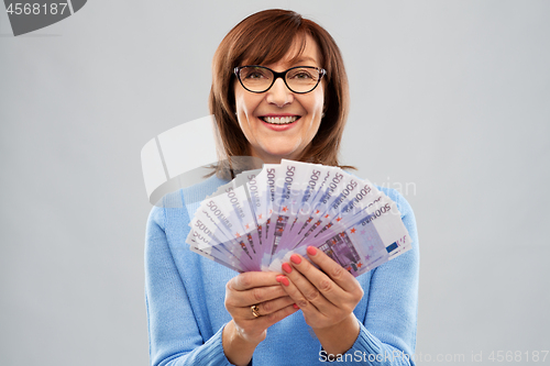 Image of senior woman holding hundred euro money banknotes