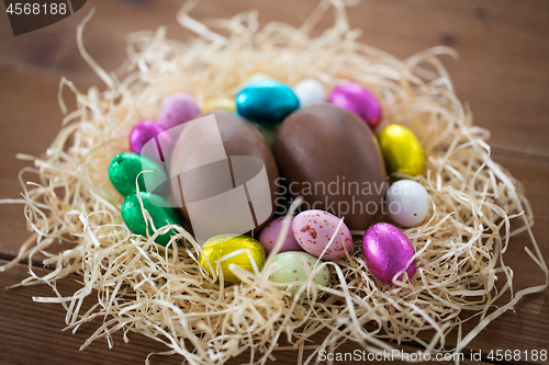 Image of chocolate eggs in foil wrappers in straw nest