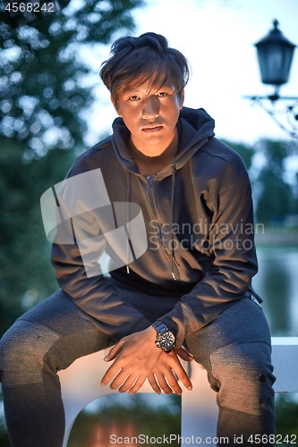 Image of Outdoor portrait of a young Asian guy