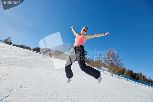 Image of Woman jumping on a ski track in sunlight