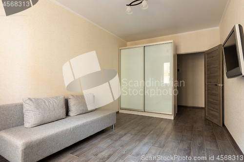 Image of Interior of a small hotel room, TV, wardrobe and sofa