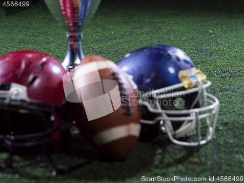 Image of closeup of american football,helmets and trophy