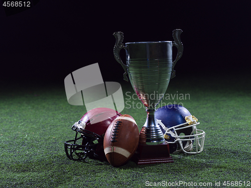 Image of closeup of american football,helmets and trophy