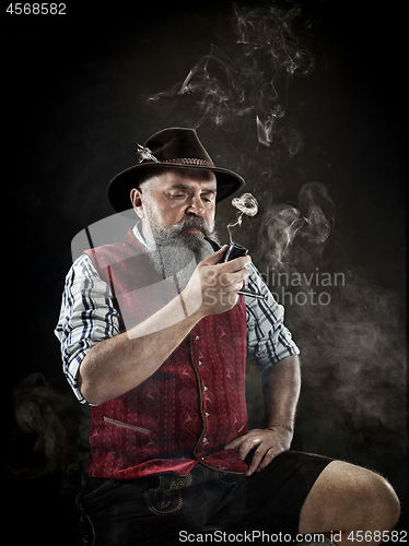 Image of dramatic portrait of senior smoking tobacco pipe