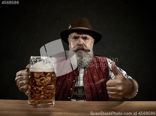 Image of Germany, Bavaria, Upper Bavaria, man with beer dressed in in traditional Austrian or Bavarian costume