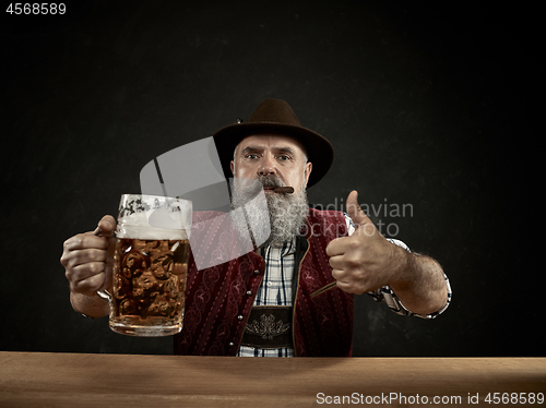 Image of Germany, Bavaria, Upper Bavaria, man with beer dressed in in traditional Austrian or Bavarian costume