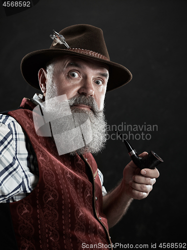 Image of dramatic portrait of senior smoking tobacco pipe