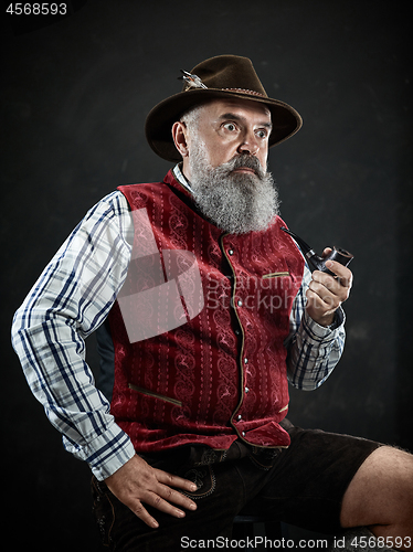 Image of dramatic portrait of senior smoking tobacco pipe