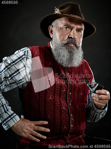 Image of dramatic portrait of senior smoking tobacco pipe