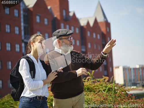 Image of Portrait of young girl embracing grandfather at park