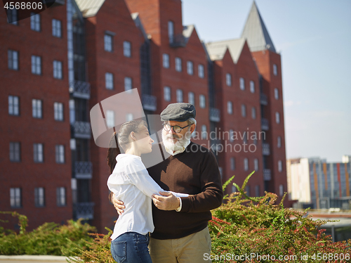 Image of Portrait of young girl embracing grandfather at park