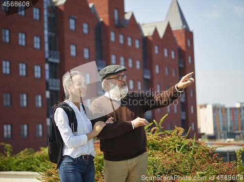 Image of Portrait of young girl embracing grandfather at park