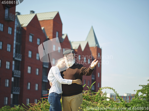 Image of Portrait of young girl embracing grandfather at park