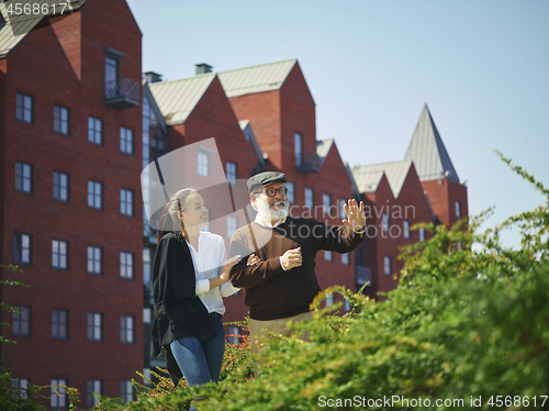 Image of Portrait of young girl embracing grandfather at park