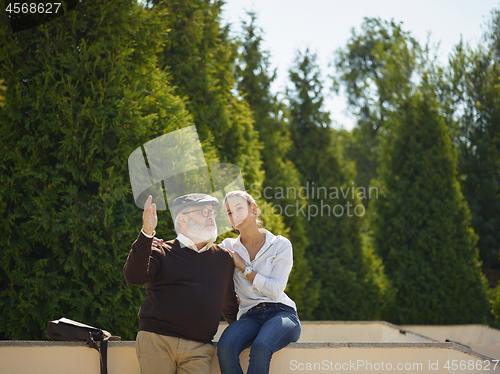 Image of Portrait of young girl embracing grandfather at park