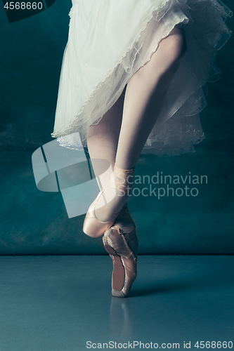 Image of Close-up ballerinas legs in pointes on the gray wooden floor