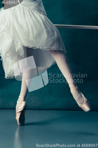 Image of Close-up ballerinas legs in pointes on the gray wooden floor