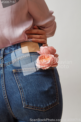 Image of Perfect woman\'s bottom in a blue jeans and fresh roses living co