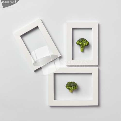 Image of Creative pattern of frames with natural organic broccoli on a light background.