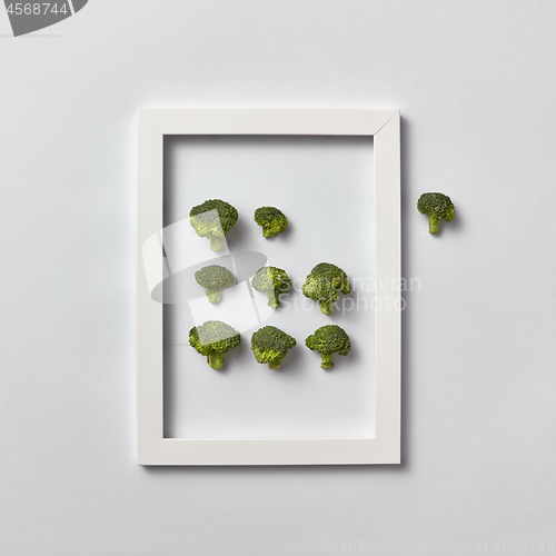 Image of Organic frame with fresh natural broccoli on a light gray background.