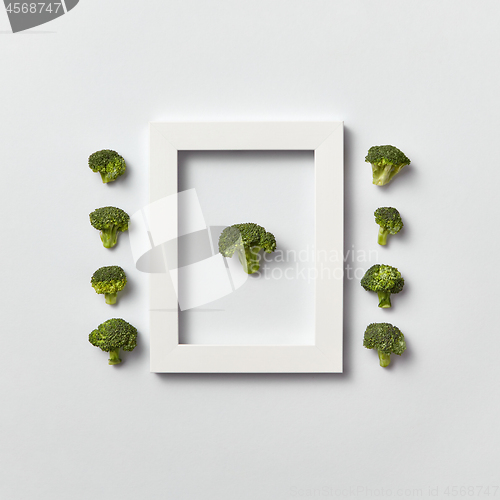 Image of Organic vegetables pattern with broccoli in a frame and out of it on a light background.