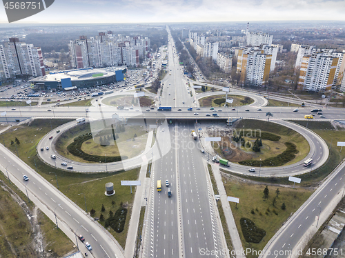 Image of Aerial view of the drone on the road junction of Odessa square with highway in the form of a quatrefoil with passing cars and a modern city against a cloudy sky. Kiev, Ukraine