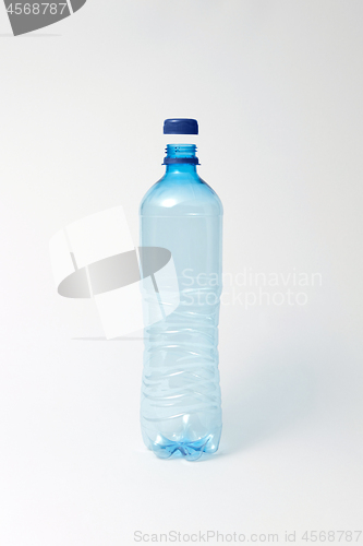 Image of Blue transparent bottle for water on a light background. Mock up.