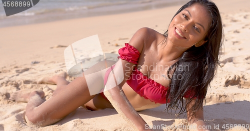 Image of Woman traveler in swimsuit having fun at sandy seashore