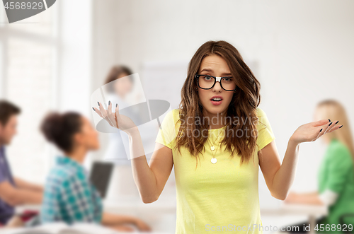 Image of confused teenage student girl in glasses at school