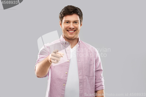 Image of smiling man pointing fingers at you