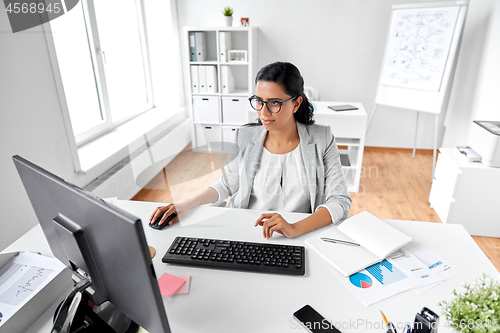 Image of businesswoman with computer working at office