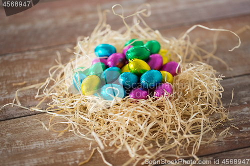 Image of chocolate eggs in foil wrappers in straw nest