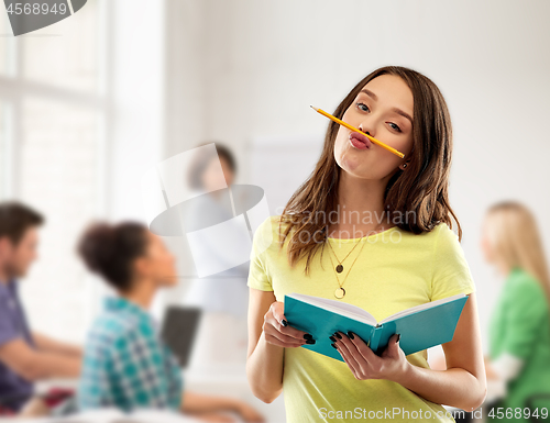 Image of teenage student girl with notebook at school