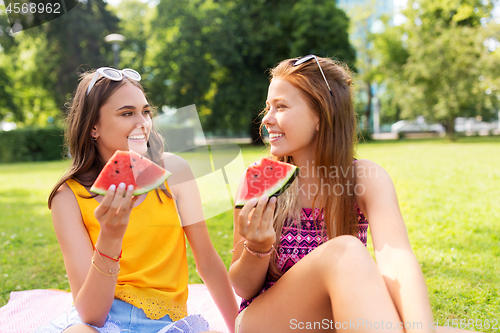 Image of teenage girls eating watermelon at picnic in park