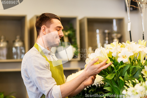Image of florist or seller with white lilies at flower shop