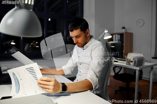 Image of businessman with papers working at night office