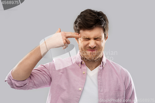 Image of man making headshot by finger gun gesture