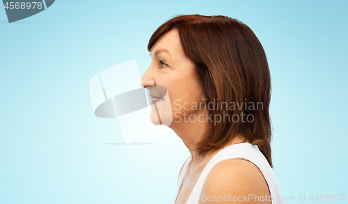 Image of profile of smiling senior woman over white