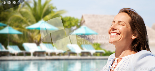 Image of happy woman over swimming pool of touristic resort