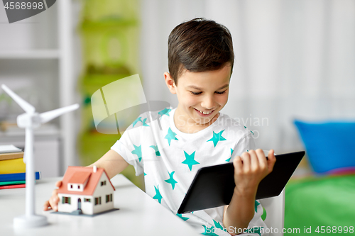 Image of boy with tablet, toy house and wind turbine