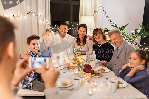 Image of family having dinner party and taking selfie