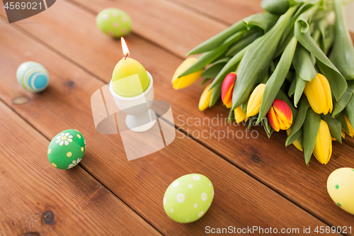 Image of candle in shape of easter egg and tulip flowers