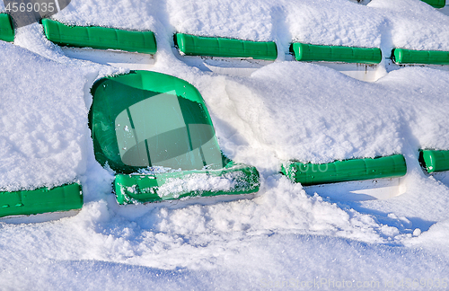 Image of Green seats of a sports stadium, covered with snow. The concept 